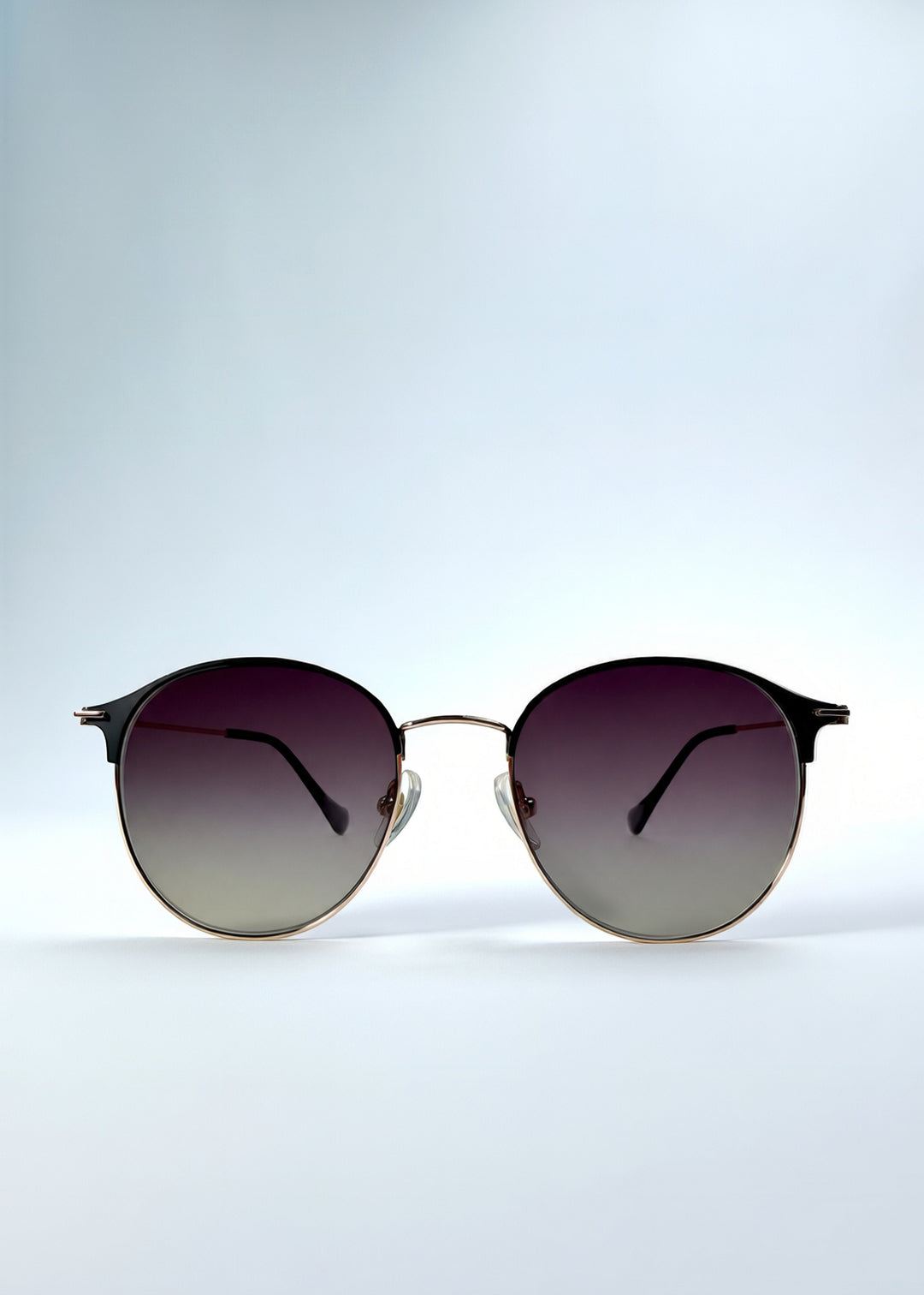 Front view of AZE Aster Line sunglasses in Duskgold, featuring a gold-tone rounded frame and plum-to-amber gradient lenses, showing the full front silhouette.