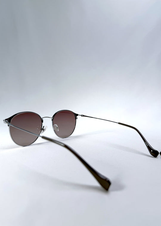 Back-angle view of AZE Aster Line sunglasses in Mocha Dusk, featuring a silver-tone rounded frame and taupe gradient lenses, showing the rear frame structure and temple alignment.