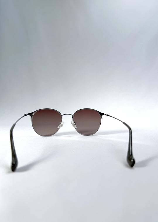 Back view of AZE Aster Line sunglasses in Mocha Dusk, featuring a silver-tone rounded frame and taupe gradient lenses, showing the inner frame and open temples.