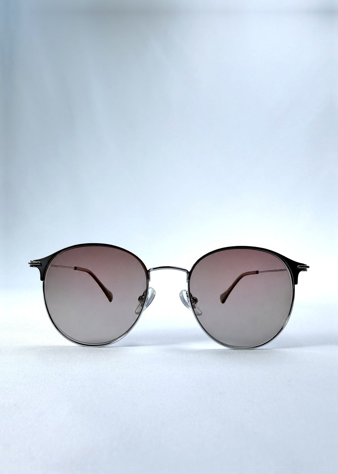 Front view of AZE Aster Line sunglasses in Mocha Dusk, featuring a silver-tone rounded frame and taupe gradient lenses, showing the full front silhouette.
