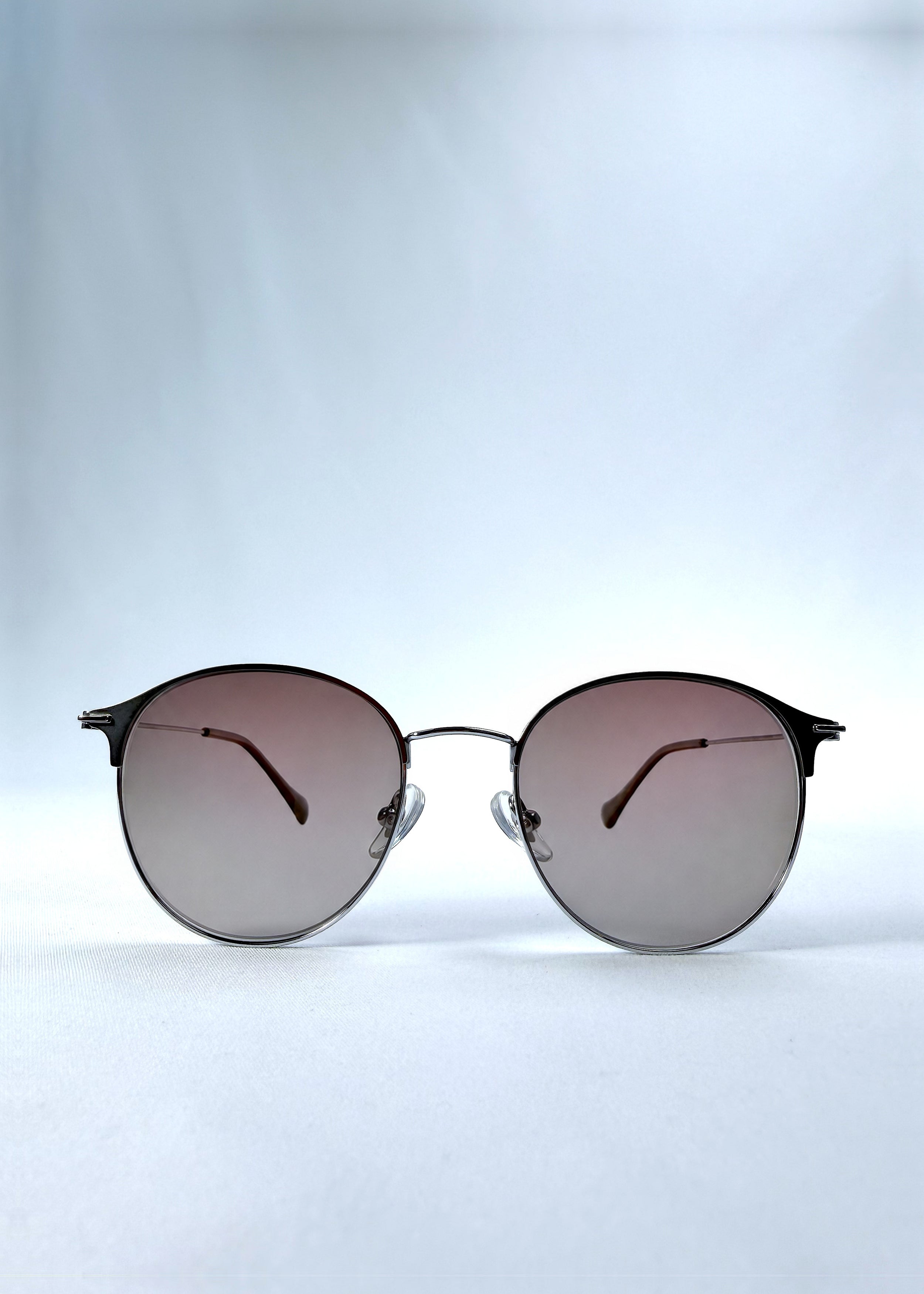 Front view of AZE Aster Line sunglasses in Mocha Dusk, featuring a silver-tone rounded frame and taupe gradient lenses, showing the full front silhouette.