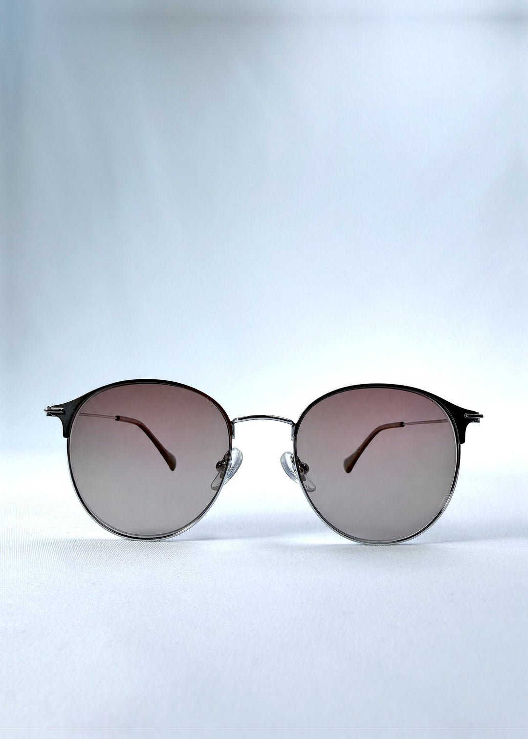 Front view of AZE Aster Line sunglasses in Mocha Dusk, featuring a silver-tone rounded frame and taupe gradient lenses, showing the full front silhouette. 