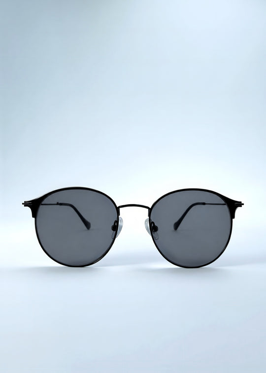Front view of AZE Aster Line sunglasses in Obsidian Black, featuring a dark geometric round frame and smoky gray lenses, showing the full front silhouette.