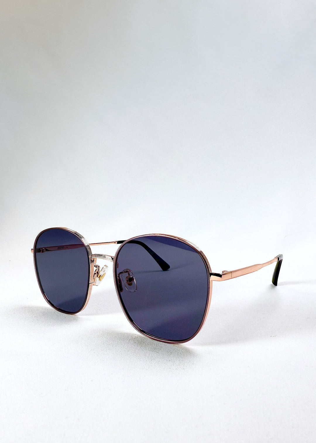 Astris Midnight Blue sunglasses – angled front perspective highlighting lens shape and rose gold rim. 