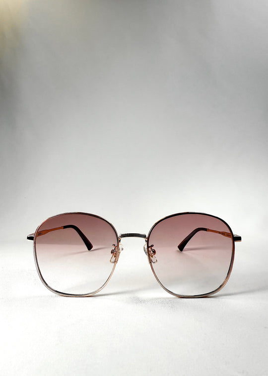 Front view of Astris – Rosé Dawn sunglasses, showcasing the soft blush gradient lenses and symmetrical rose gold frame. 