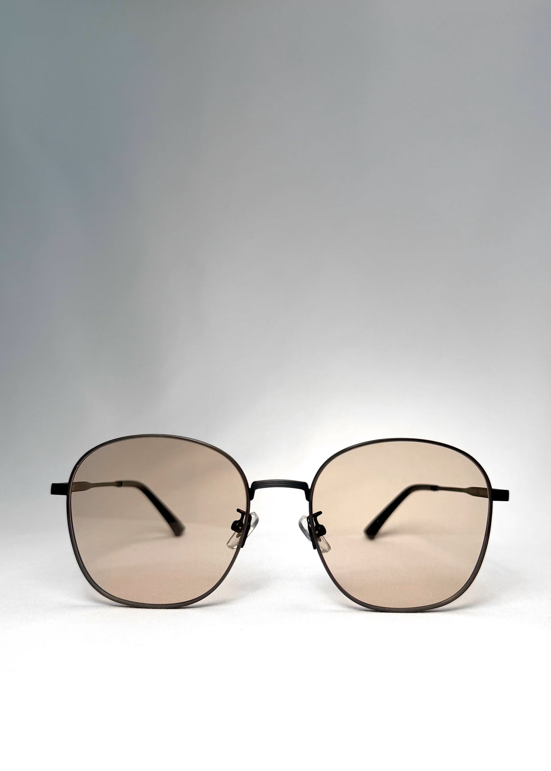 Front view of Astris sunglasses in Satin Bronze with rounded square lenses and warm tea tint. 