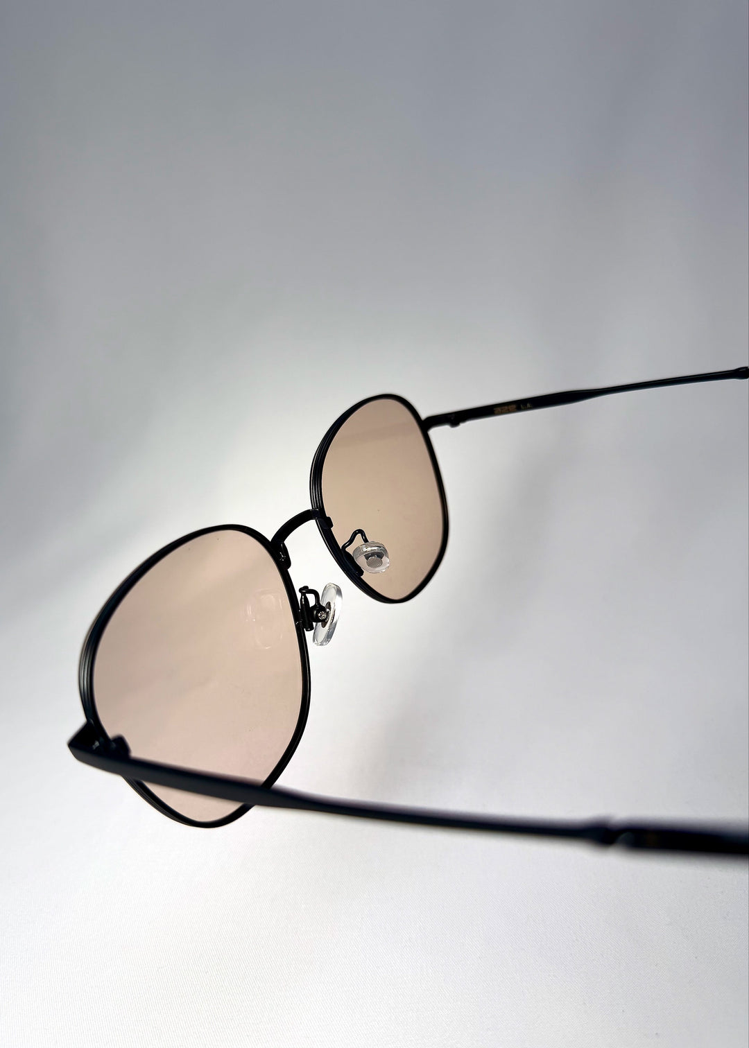 Close-up side angle of Astris in Satin Bronze, showing the slim temple and flexible nose pads. 