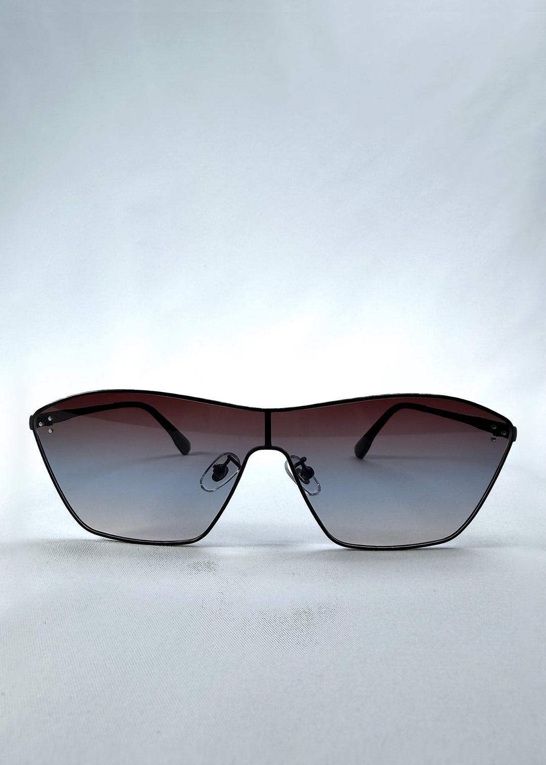 Front view of Atlas Shield sunglasses in Midnight Eclipse, featuring one-piece shield lens, slim metal frame, and dark gradient tint, showing the full front silhouette.