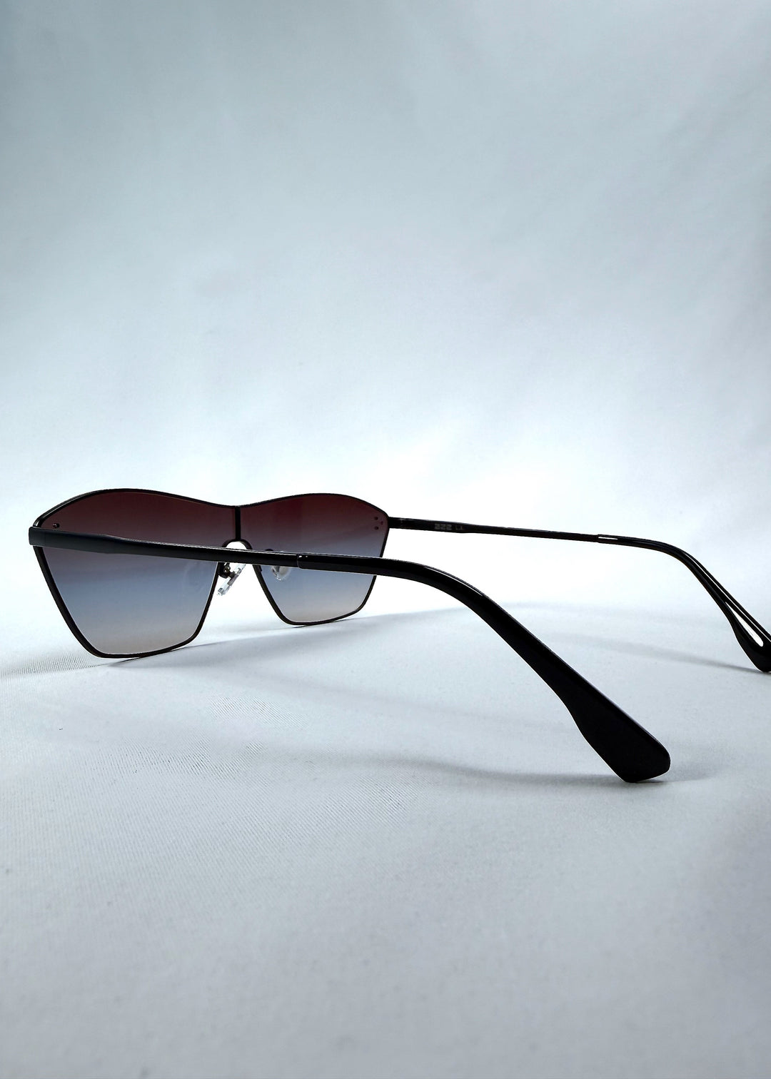 Side view of Atlas Shield sunglasses in Midnight Eclipse, featuring one-piece shield lens, slim metal frame, and dark gradient tint, showing the lens shape and temple profile.
