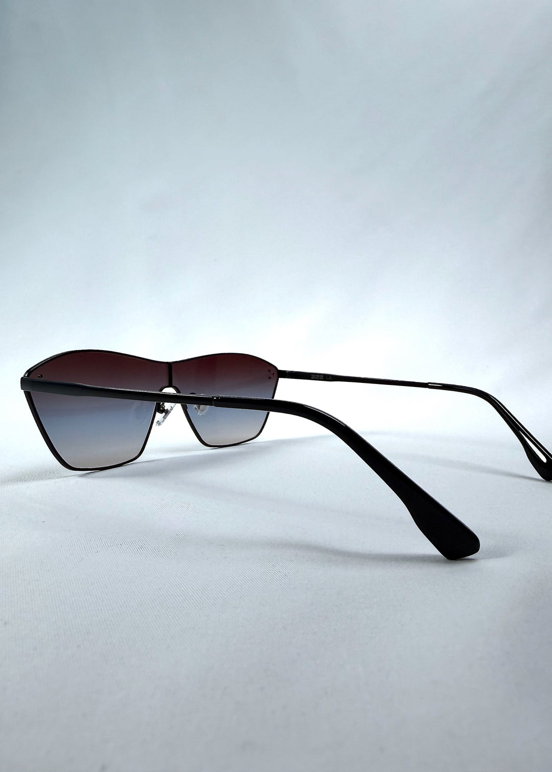 Side view of Atlas Shield sunglasses in Midnight Eclipse, featuring one-piece shield lens, slim metal frame, and dark gradient tint, showing the lens shape and temple profile. 