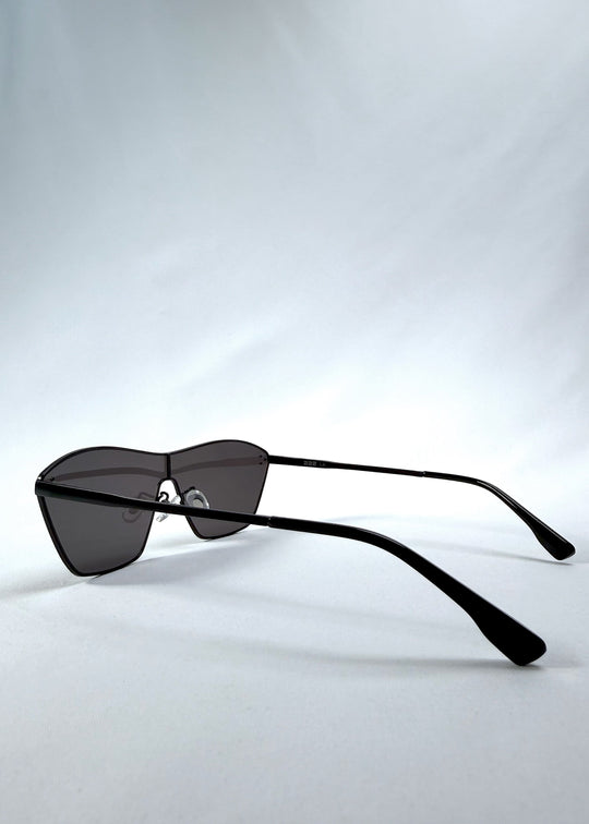 Side view of Atlas Shield sunglasses in Slate Smoke, featuring one-piece shield lens, slim metal frame, and full grey tint, showing the lens shape and temple profile. 