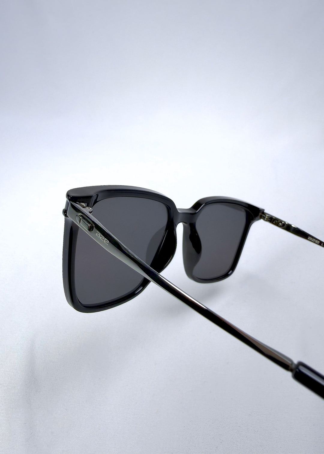 Back-angle view of Auralis sunglasses in Duskgold, featuring black and gold frame with dark lenses, showing the back structure and temple alignment. 