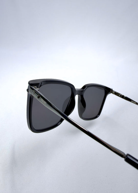 Back-angle view of Auralis sunglasses in Duskgold, featuring black and gold frame with dark lenses, showing the back structure and temple alignment. 