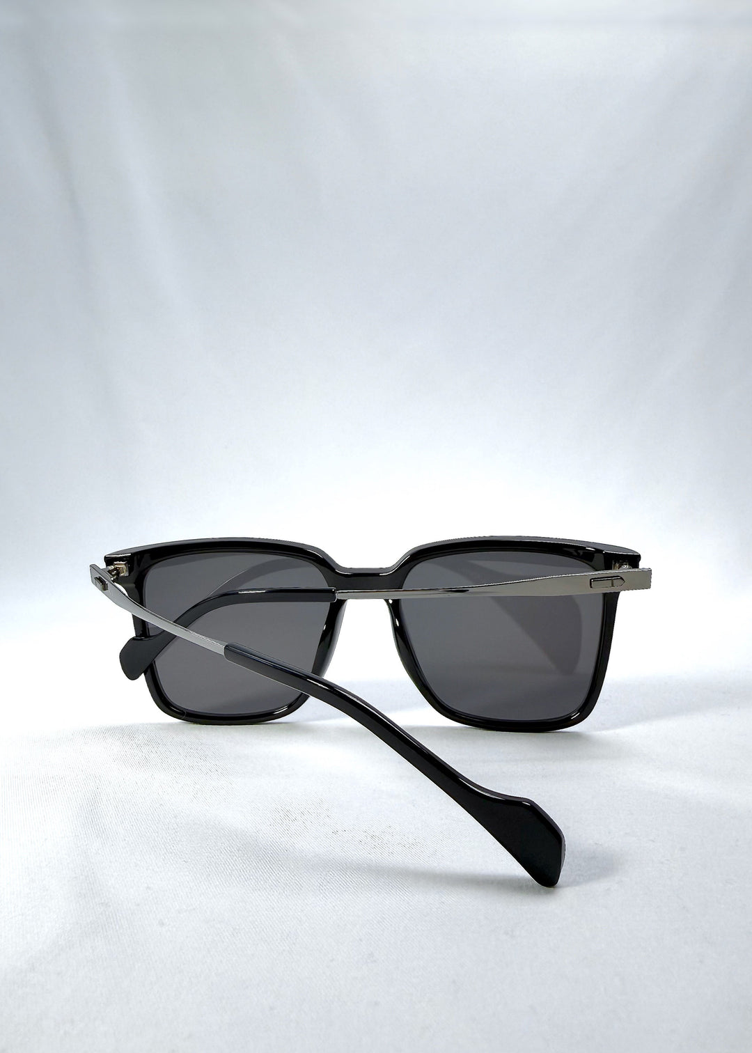 Folded view of Auralis sunglasses in Duskgold, featuring black and gold frame with dark lenses, showing the folded temples and frame profile. 