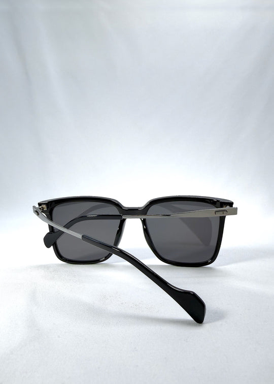 Folded view of Auralis sunglasses in Duskgold, featuring black and gold frame with dark lenses, showing the folded temples and frame profile. 