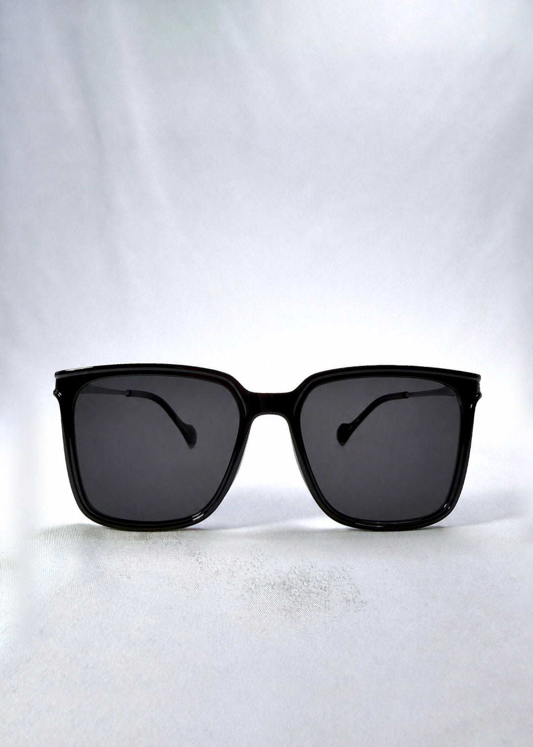 Front view of Auralis sunglasses in Duskgold, featuring black and gold frame with dark lenses, showing the full front silhouette.