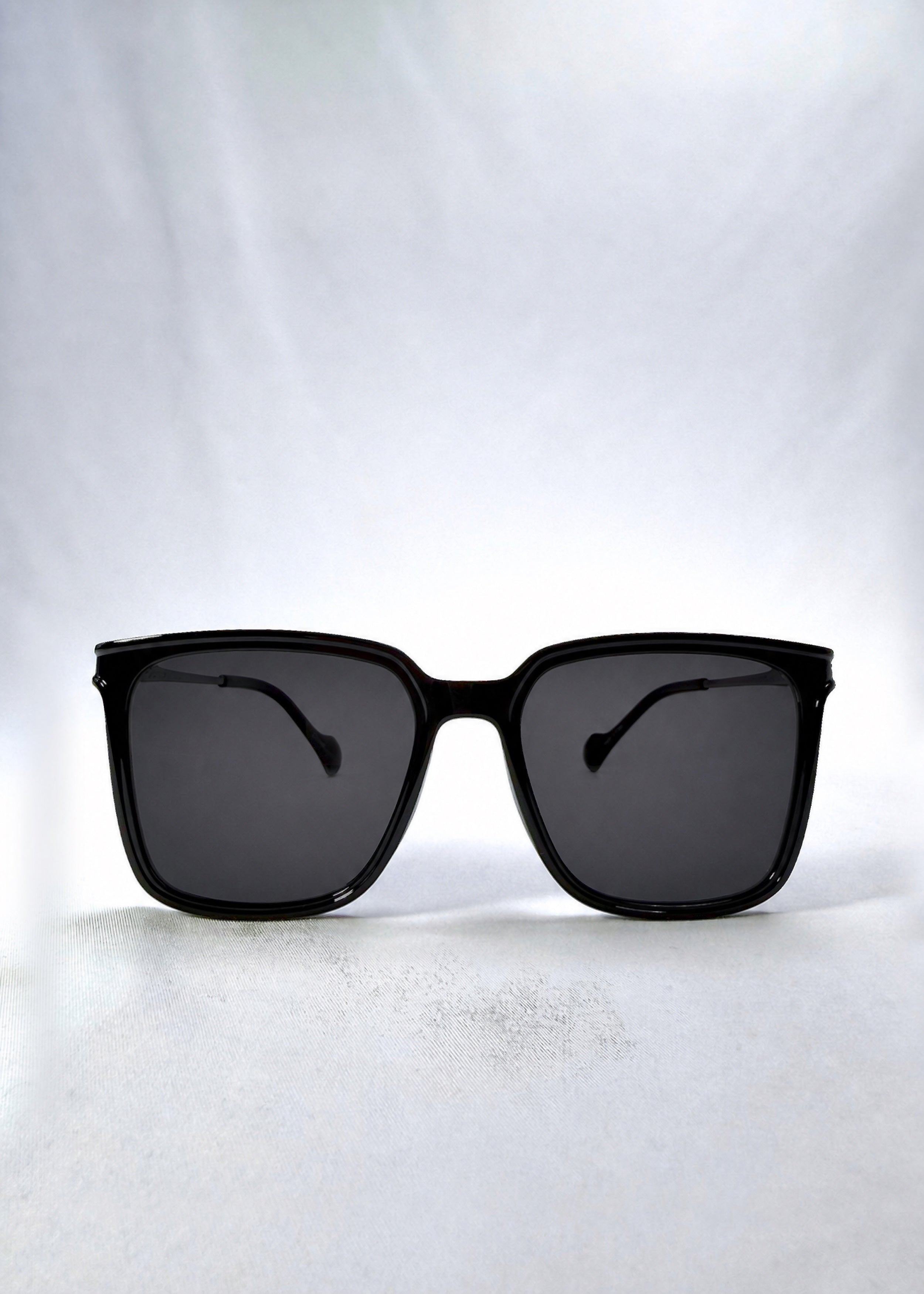 Front view of Auralis sunglasses in Duskgold, featuring black and gold frame with dark lenses, showing the full front silhouette.
