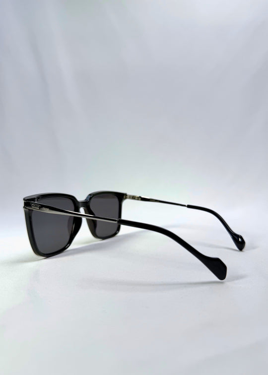 Side-angle view of Auralis sunglasses in Duskgold, featuring black and gold frame with dark lenses, showing the lens shape and side temple profile.