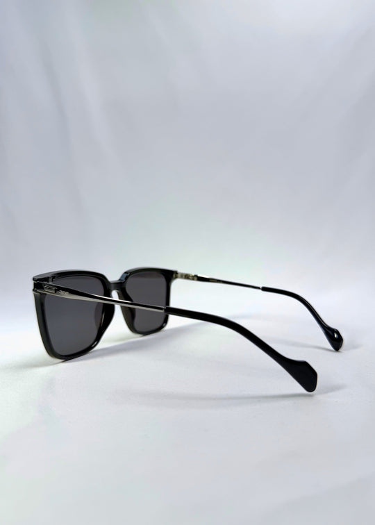 Side-angle view of Auralis sunglasses in Duskgold, featuring black and gold frame with dark lenses, showing the lens shape and side temple profile. 