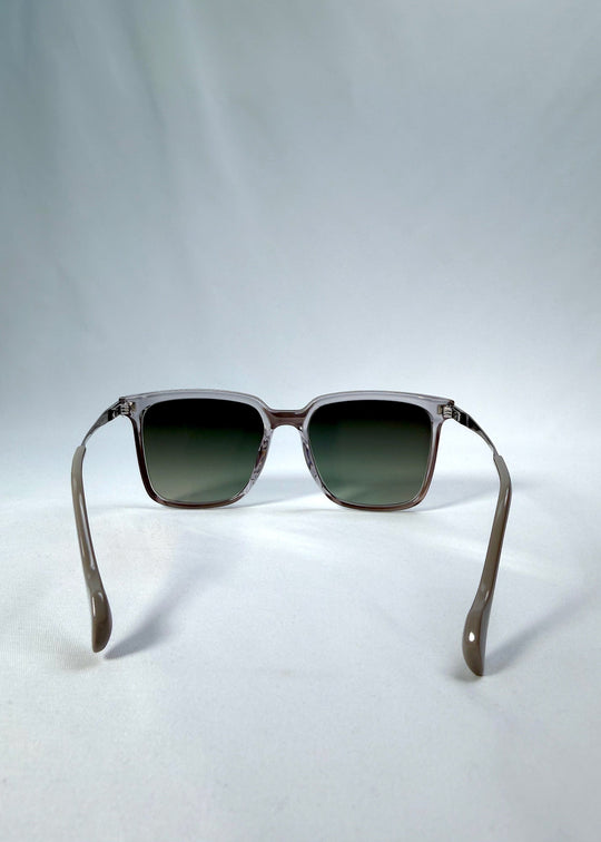 Back view of Auralis sunglasses in Rose Graphite, featuring rose graphite frame and green gradient lenses, showing the inside frame and open temples. 