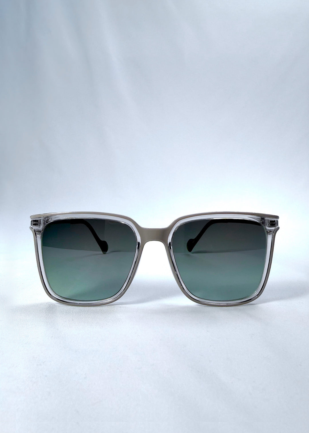 Front view of Auralis sunglasses in Rose Graphite, featuring rose graphite frame and green gradient lenses, showing the full front silhouette.