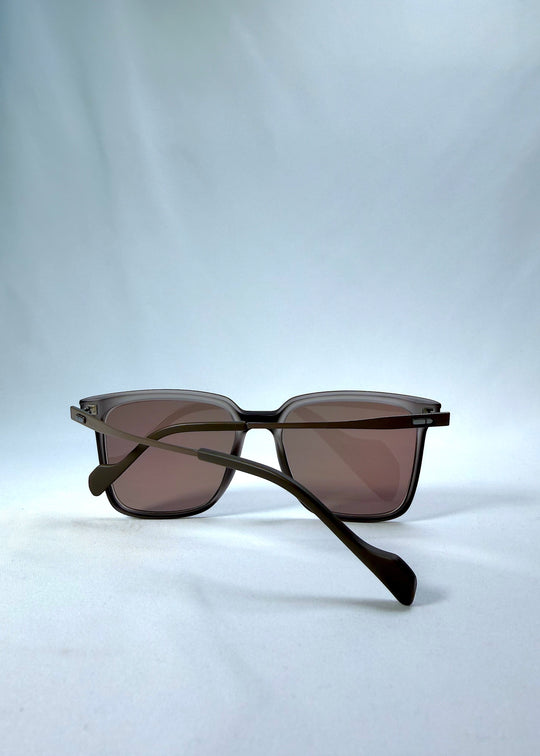 Folded back view of Auralis sunglasses in Sand Amber, featuring sand amber frame and brown lenses, showing the folded temples and back structure.