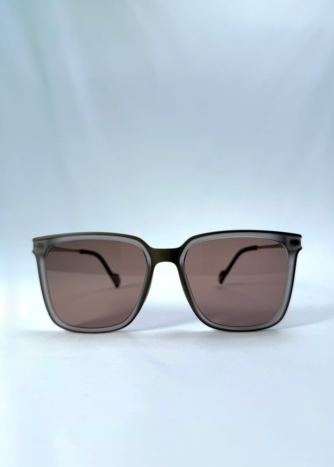 Front view of Auralis sunglasses in Sand Amber, featuring sand amber frame and brown lenses, showing the full front silhouette.