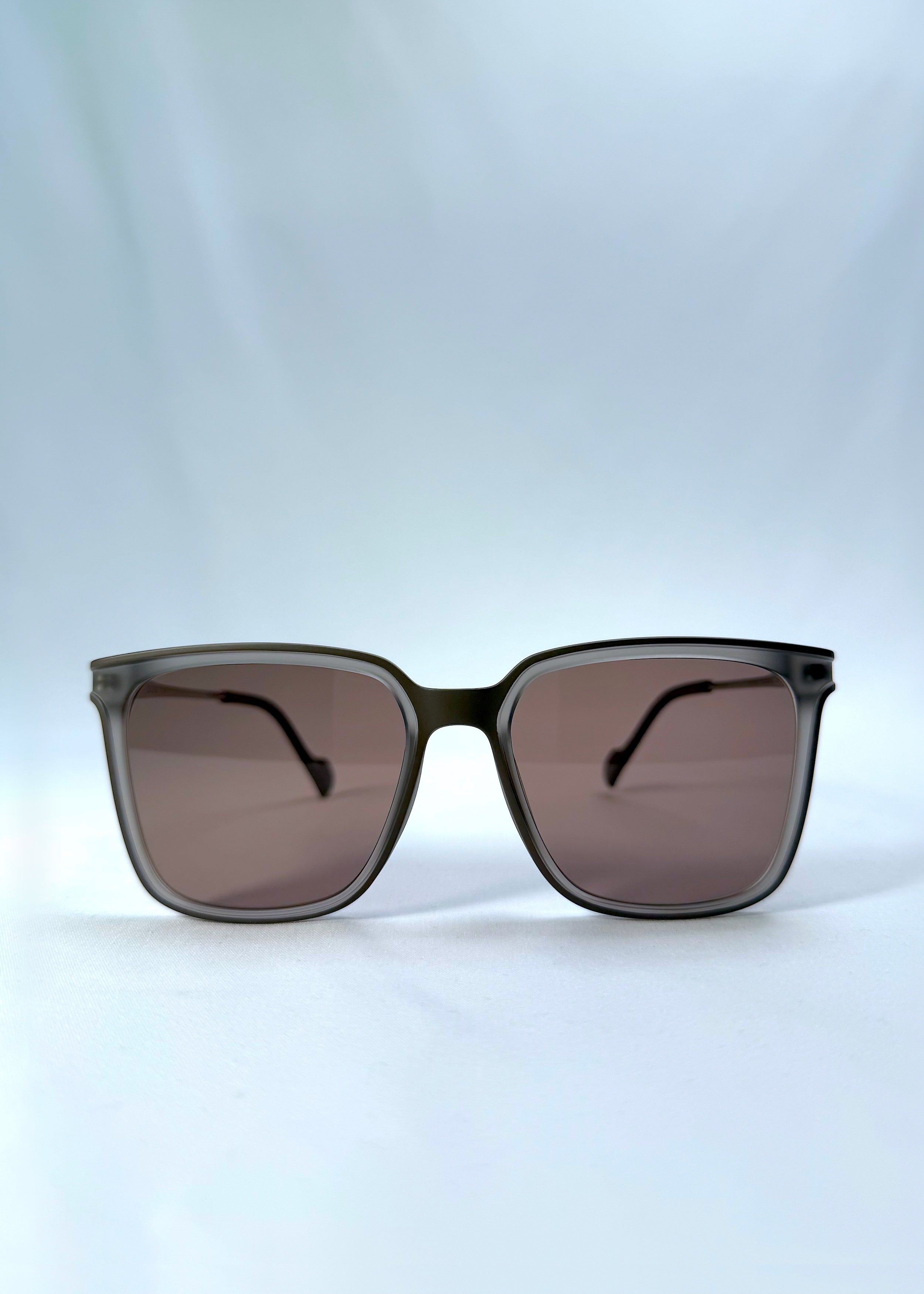 Front view of Auralis sunglasses in Sand Amber, featuring sand amber frame and brown lenses, showing the full front silhouette.