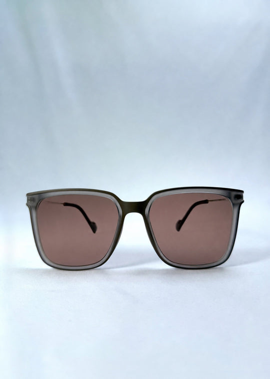Front view of Auralis sunglasses in Sand Amber, featuring sand amber frame and brown lenses, showing the full front silhouette. 