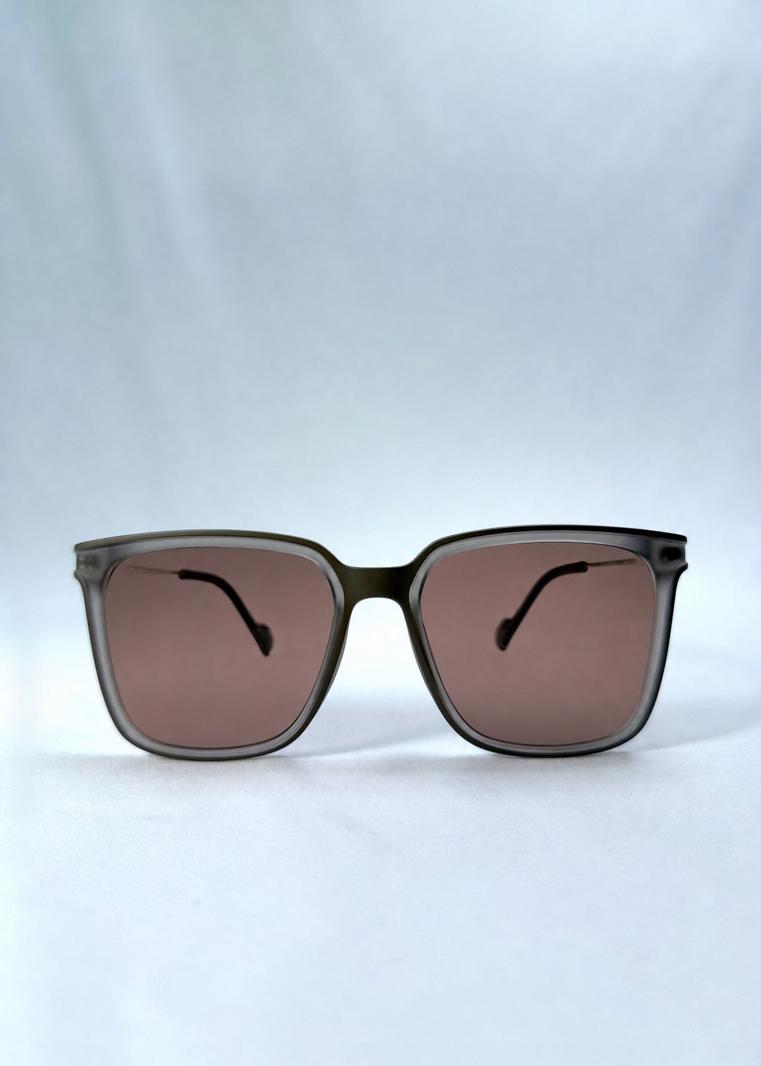 Front view of Auralis sunglasses in Sand Amber, featuring sand amber frame and brown lenses, showing the full front silhouette.