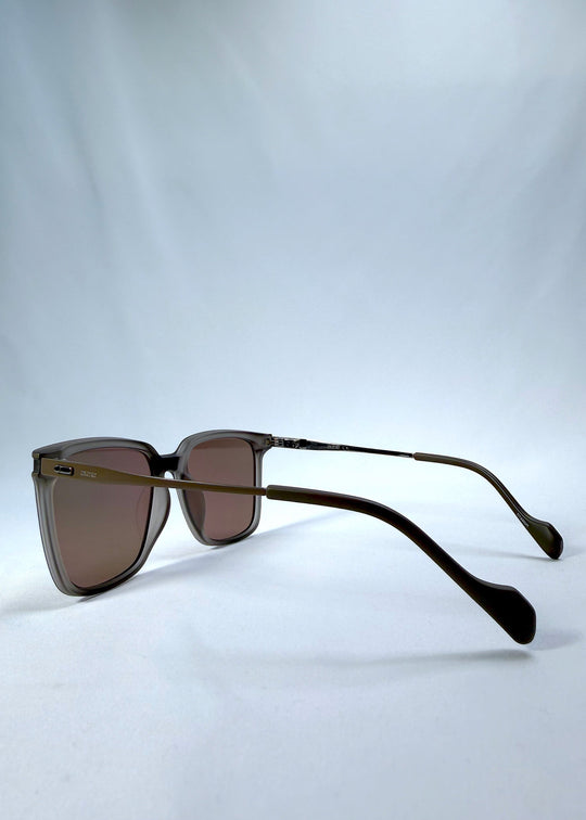 Side-angle view of Auralis sunglasses in Sand Amber, featuring sand amber frame and brown lenses, showing the lens shape and side temple profile. 