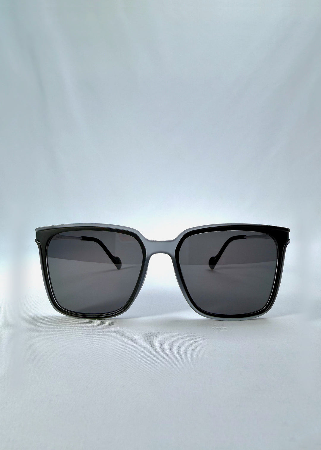 Front view of Auralis sunglasses in Sand Haze, featuring sand-toned frame and dark lenses, showing the full front silhouette.