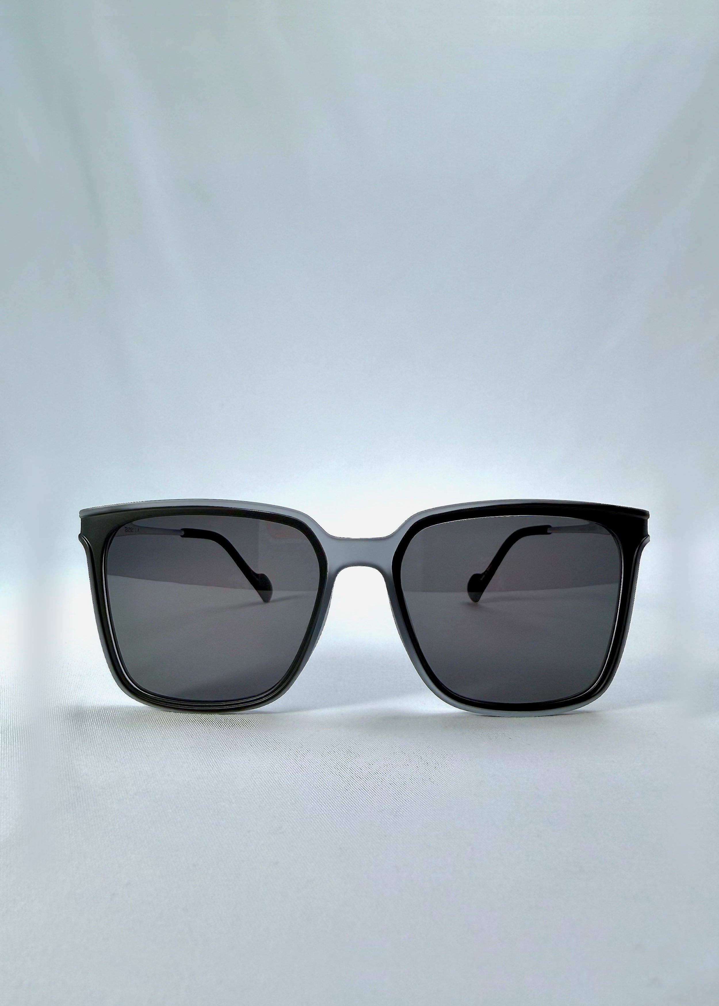 Front view of Auralis sunglasses in Sand Haze, featuring sand-toned frame and dark lenses, showing the full front silhouette.