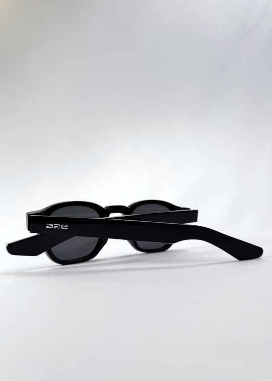 Folded back view of Auren Black sunglasses displaying wide temples and compact sizing. 