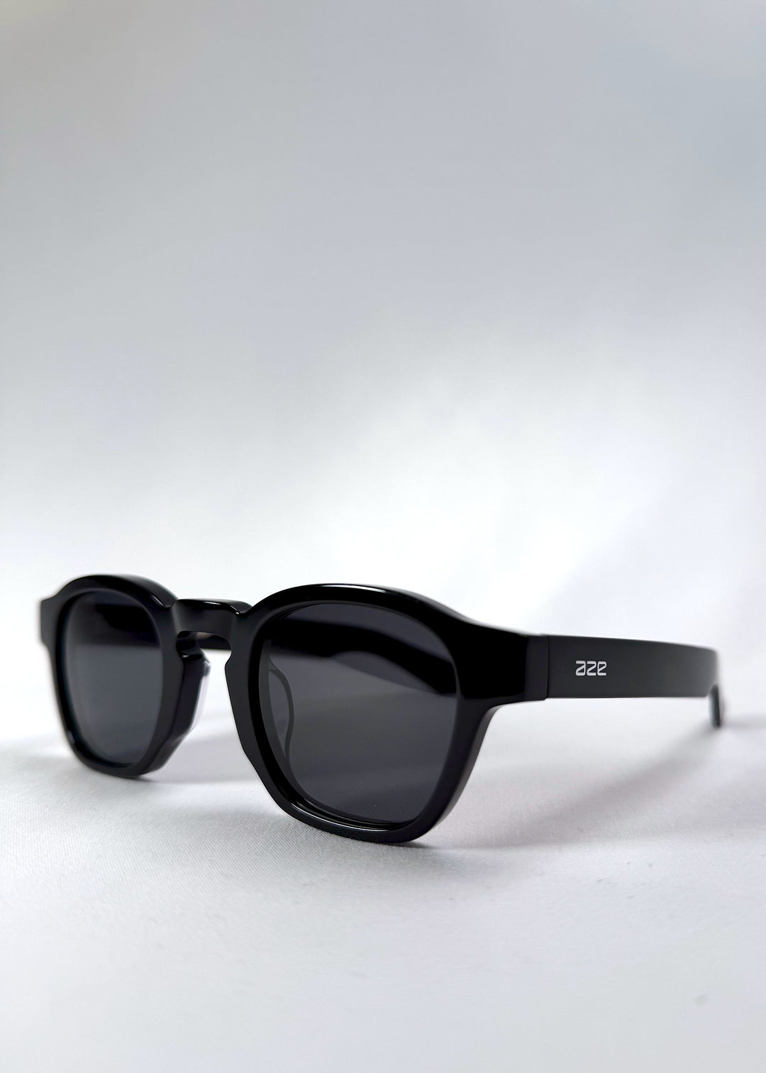 Angled front view of Auren Black sunglasses highlighting the sculpted bridge and round lens shape. 