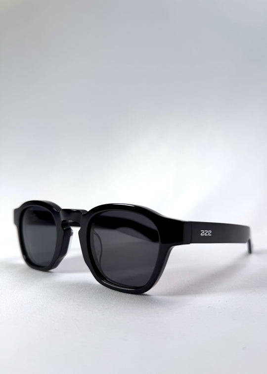 Angled front view of Auren Black sunglasses highlighting the sculpted bridge and round lens shape. 