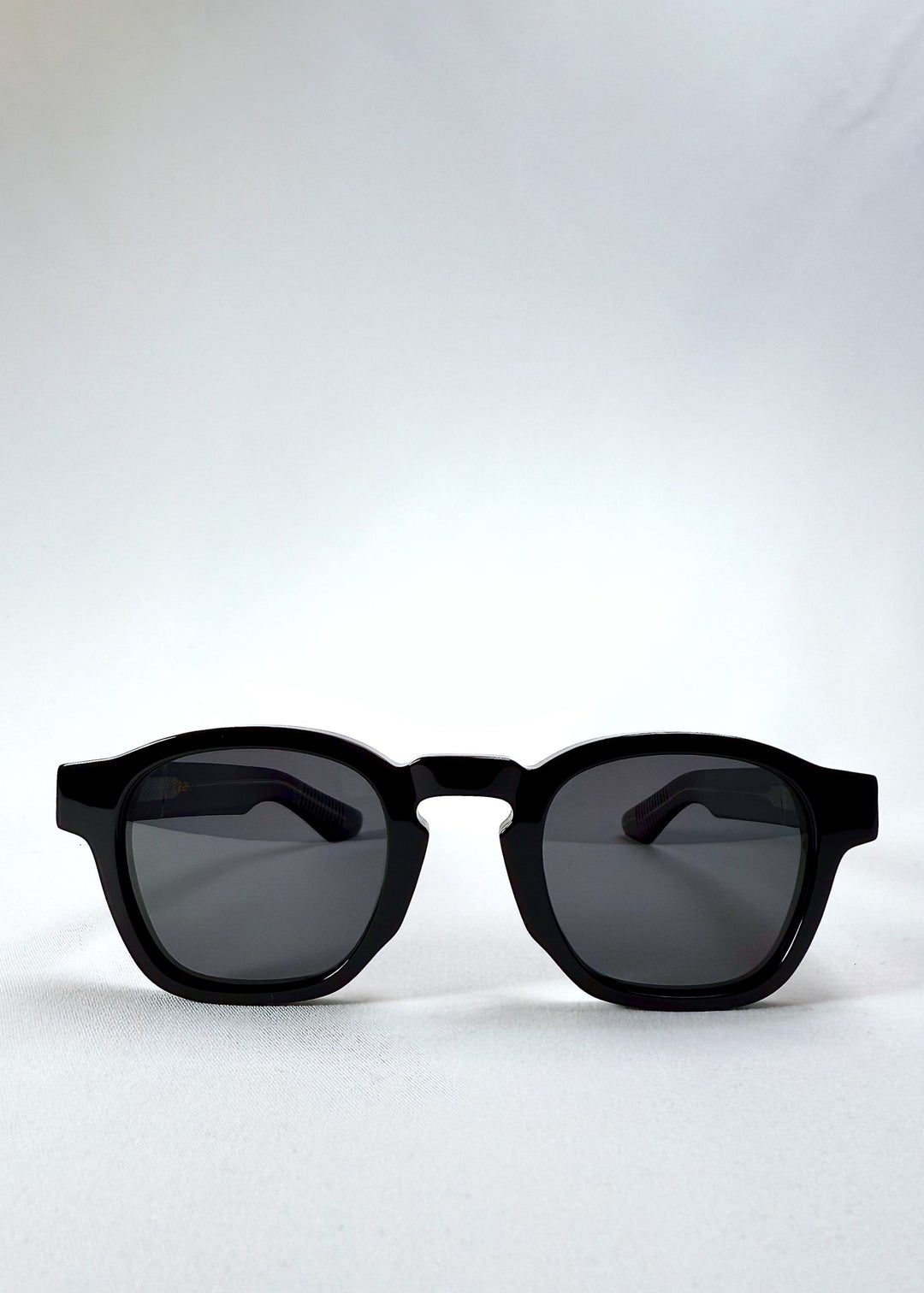 Auren Black sunglasses front view showing the bold round frame and glossy acetate finish. 