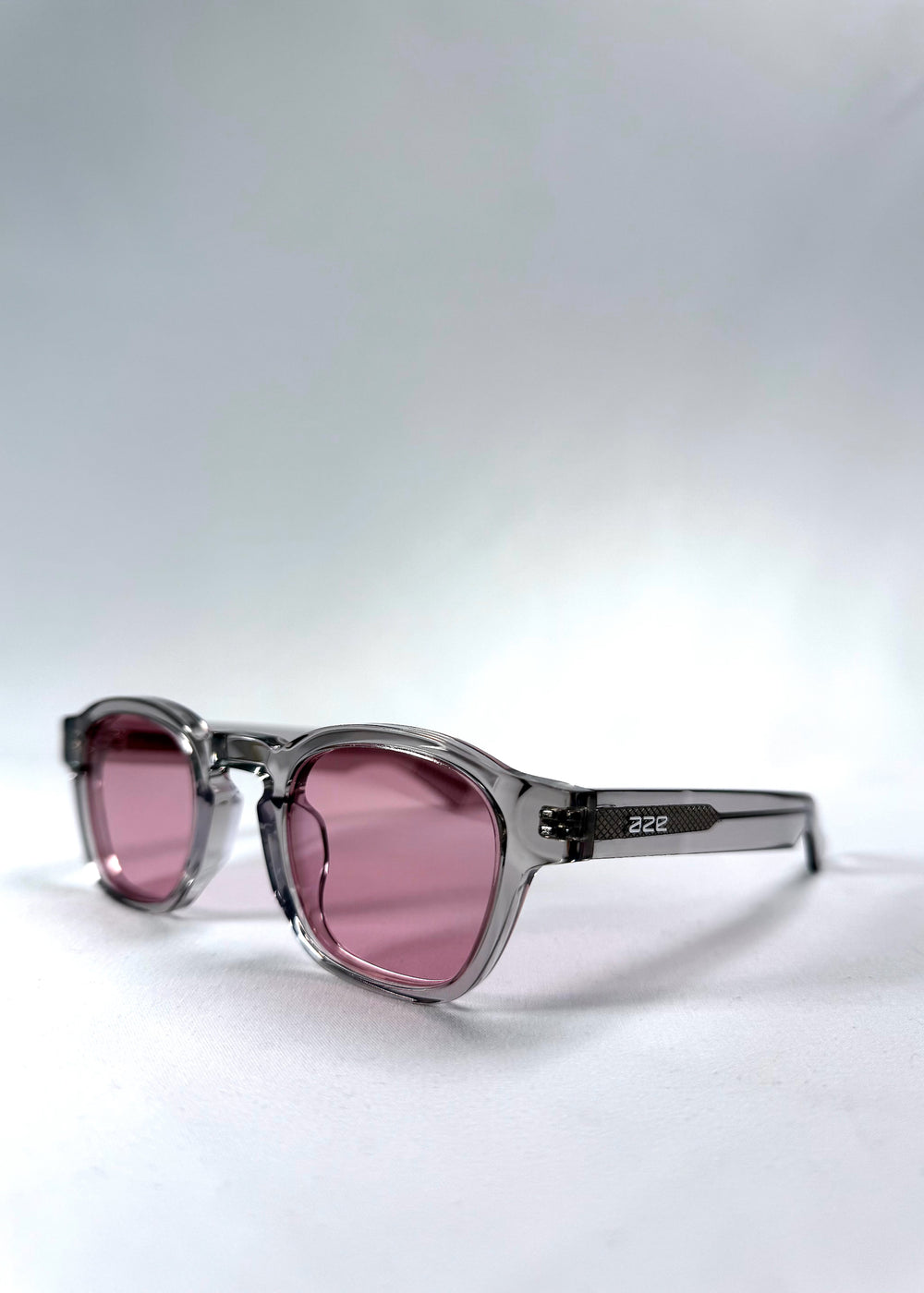 Front angle view of Auren Blush Grey sunglasses highlighting the curved round frame and subtle pink lenses.