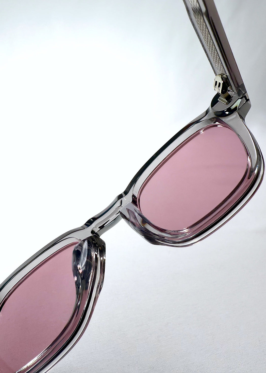 Inside view of Auren Blush Grey sunglasses focusing on the blush lenses and embedded metal hinge details. 