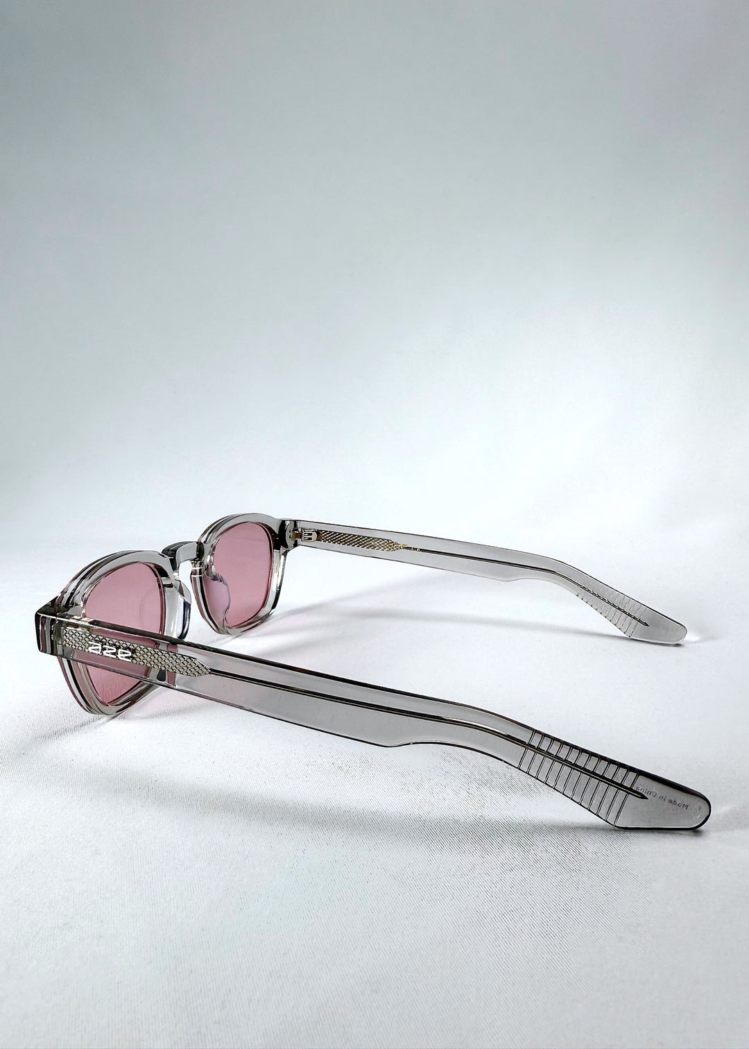 Side view of Auren in Blush Grey emphasizing the slender arms and silver-toned Aze logo detail.