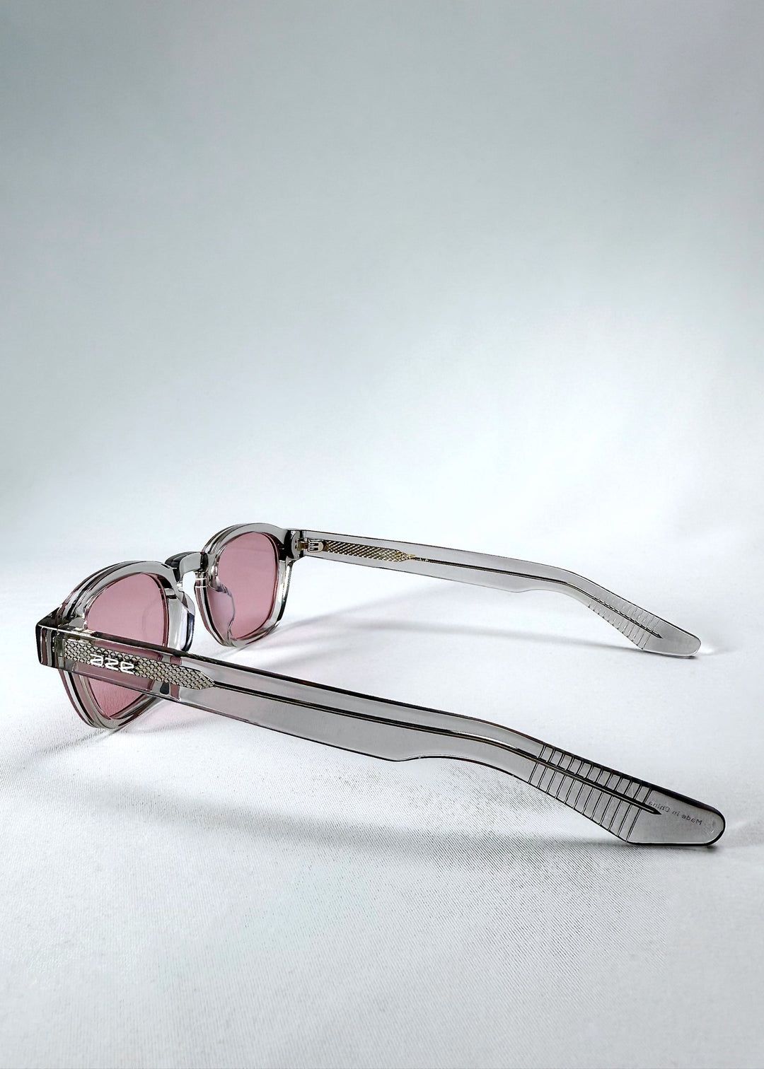 Side view of Auren in Blush Grey emphasizing the slender arms and silver-toned Aze logo detail. 