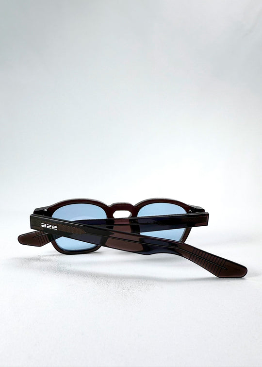 Folded view of Auren Mahogany Smoke sunglasses emphasizing the compact silhouette and arm detailing. 