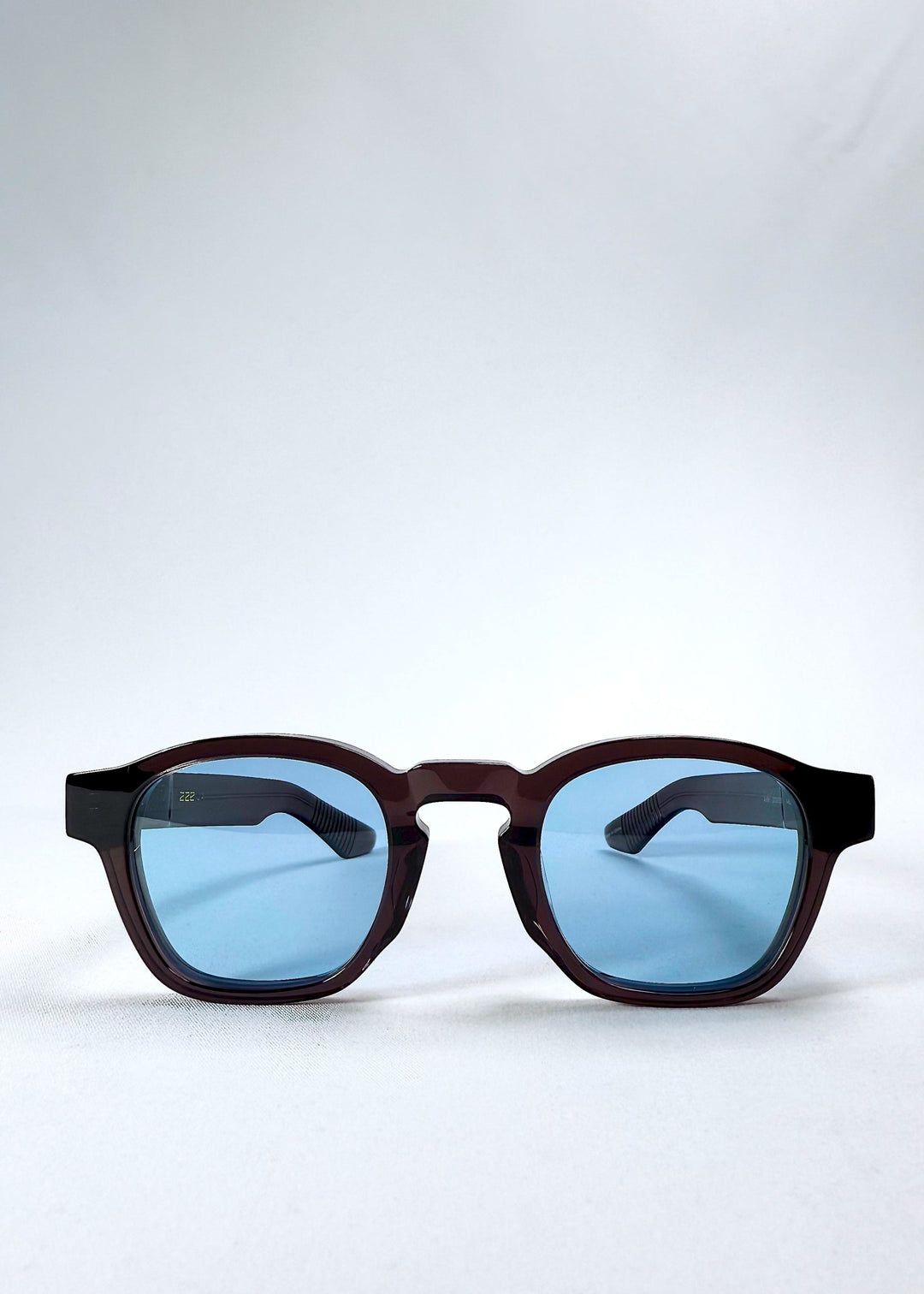 Front view of Auren Mahogany Smoke sunglasses featuring a rounded frame in translucent brown with smoky blue lenses. 