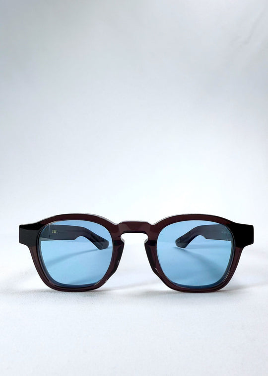 Front view of Auren Mahogany Smoke sunglasses featuring a rounded frame in translucent brown with smoky blue lenses. 