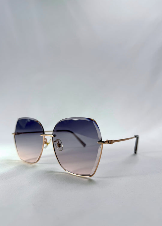 Three-quarter front view of Aureon sunglasses in Rosé Quartz, featuring rimless metal frame, pale metal temples, and pink-grey gradient lenses, showing the front shape and temple profile.