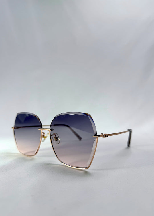Three-quarter front view of Aureon sunglasses in Rosé Quartz, featuring rimless metal frame, pale metal temples, and pink-grey gradient lenses, showing the front shape and temple profile. 