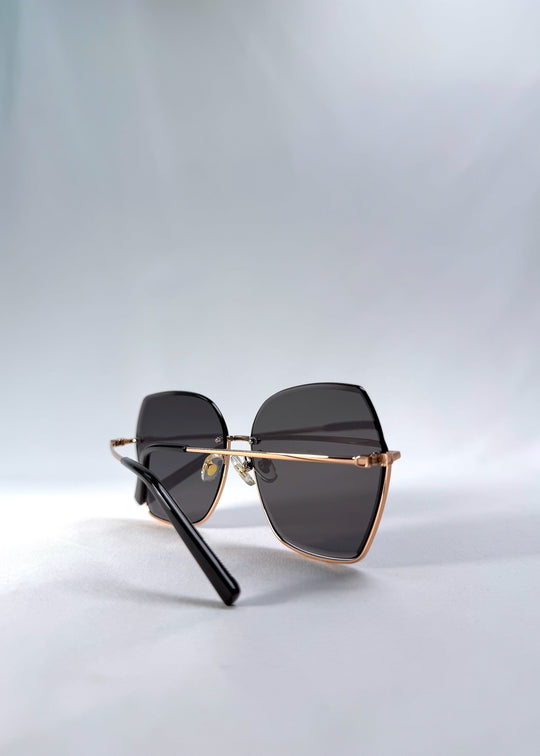 Folded view of Aureon sunglasses in Silver Smoke, featuring rimless metal frame, silver temples, and grey lenses, showing the folded temples and frame profile. 