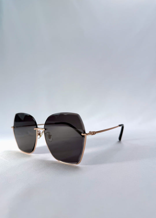 Three-quarter front view of Aureon sunglasses in Silver Smoke, featuring rimless metal frame, silver temples, and grey lenses, showing the front shape and temple profile. 