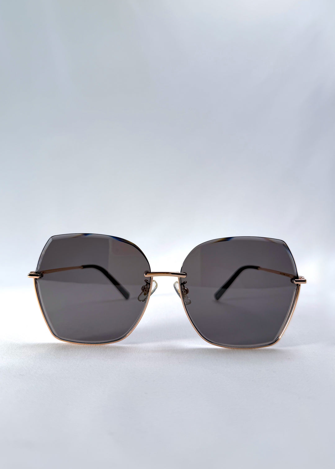 Front view of Aureon sunglasses in Silver Smoke, featuring rimless metal frame, silver temples, and grey lenses, showing the full front silhouette.