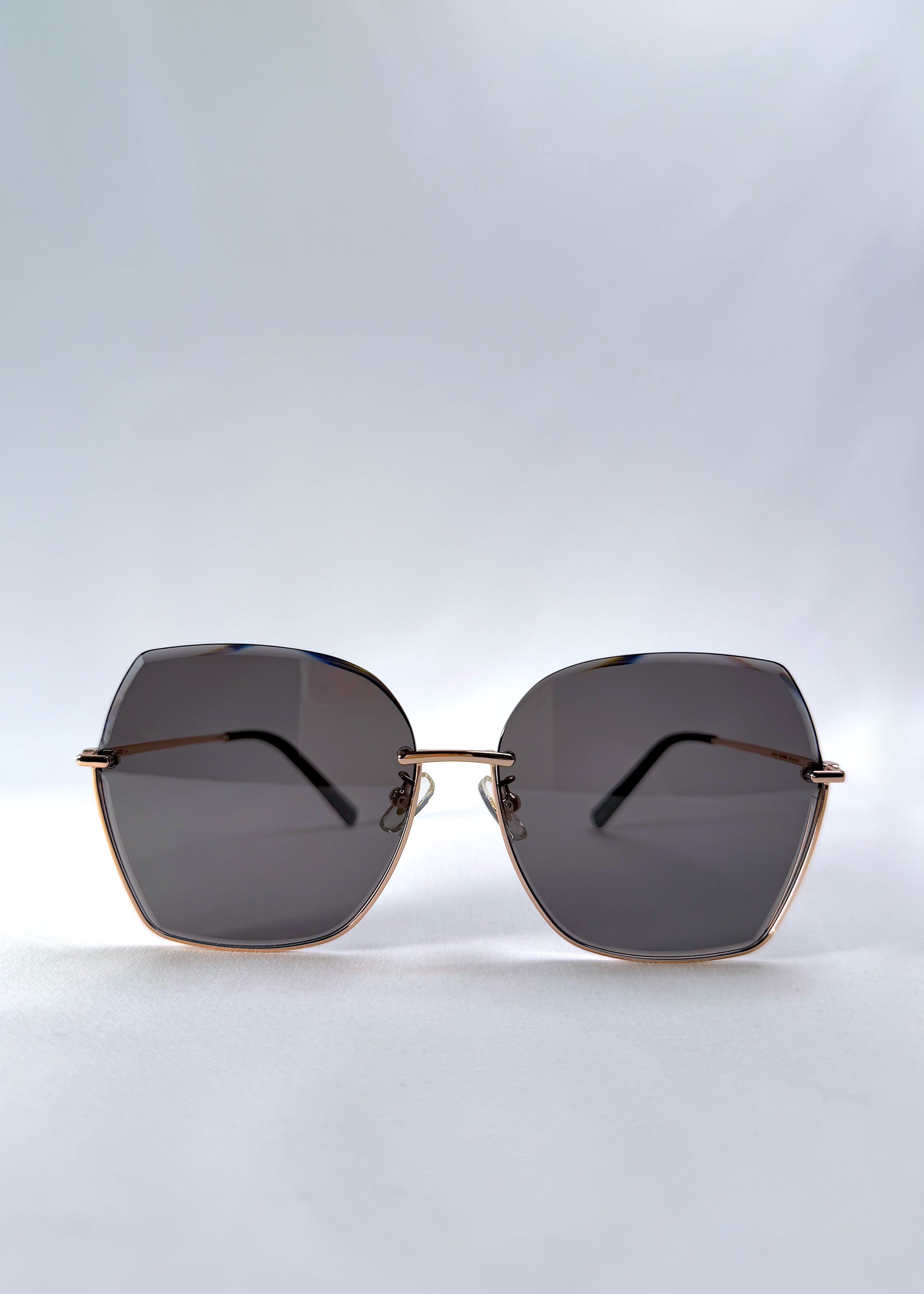 Front view of Aureon sunglasses in Silver Smoke, featuring rimless metal frame, silver temples, and grey lenses, showing the full front silhouette.
